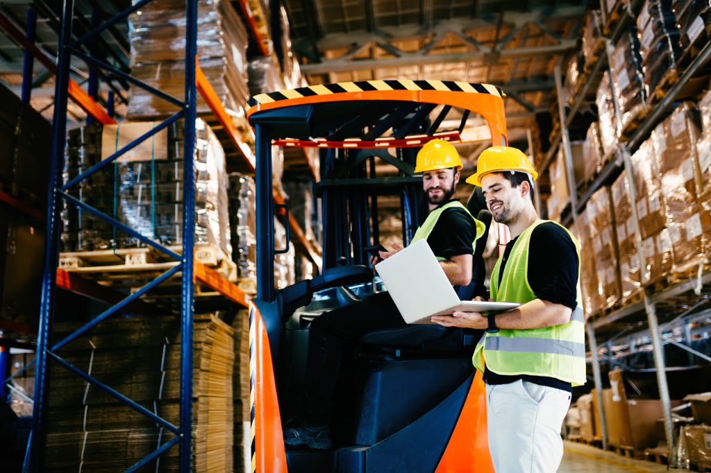 Warehouse workers working together with forklift loader